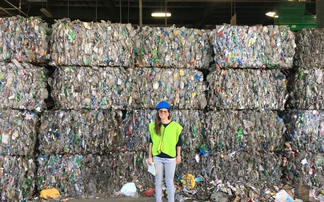 girl standing in front of blocks of rubbish