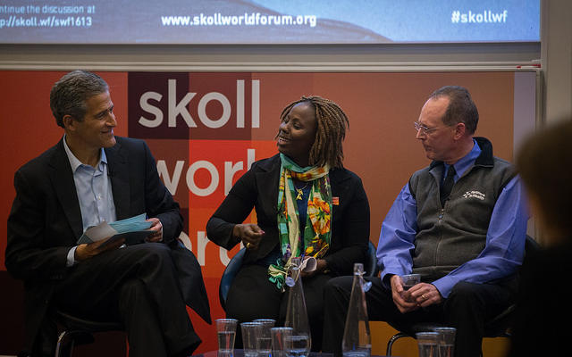 panel discussion at Skoll World Forum. Three people on a stage.