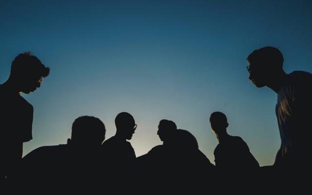 silhouettes of a group of teenagers in late evening