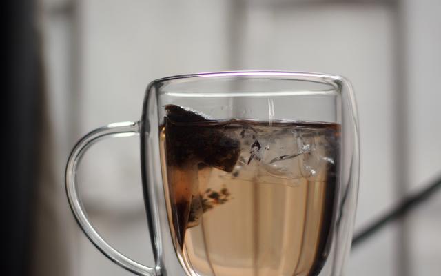 Glass mug with herbal tea in a teabag stewing inside water