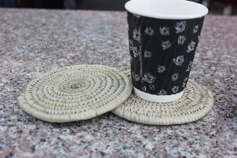 coffee cup on top of a woven coaster