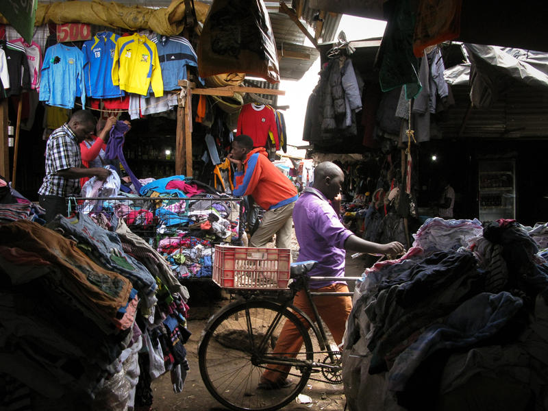 A man pushes his bicycle through Toi Market, a thriving second-hand clothing market in Nairobi that stretches multiple blocks, eventually ending in Kibera slum.