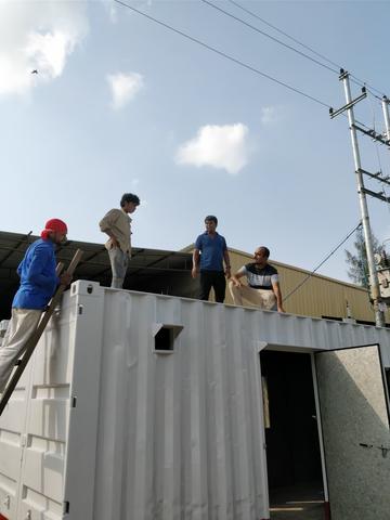 four men stood on a container